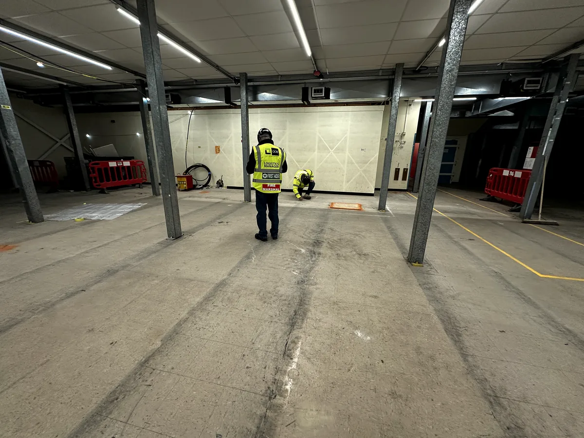Surveyor scanning a large concrete floor in a covered car park