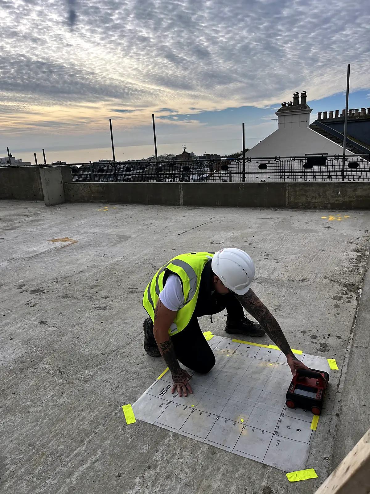 Corvus surveyor in hard hat scanning a roof slab through a grid sheet