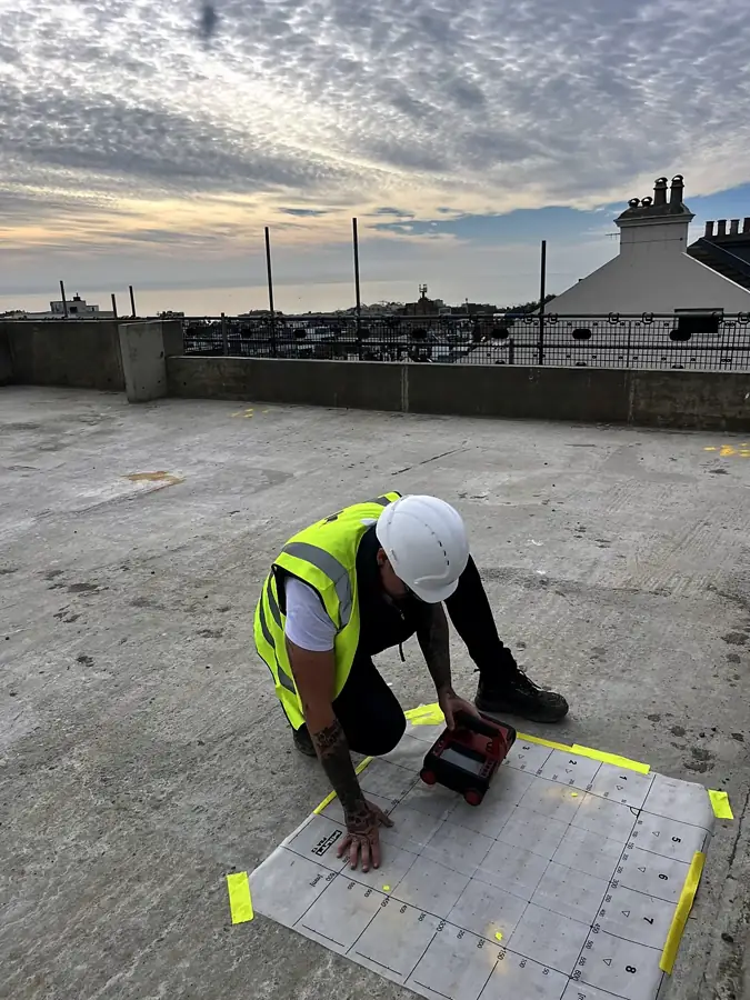 Surveyor in hard hat scanning a roof slab