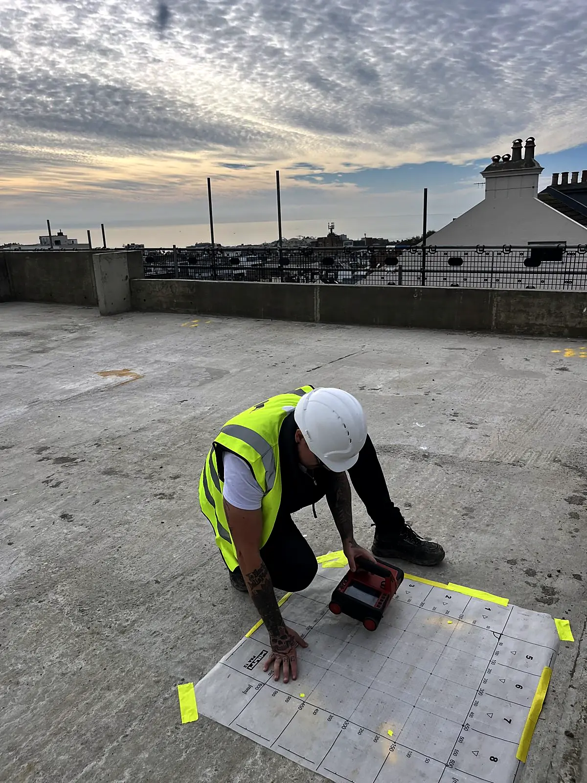 Corvus surveyor in hard hat and hi-vis scanning a roof slab in Brighton
